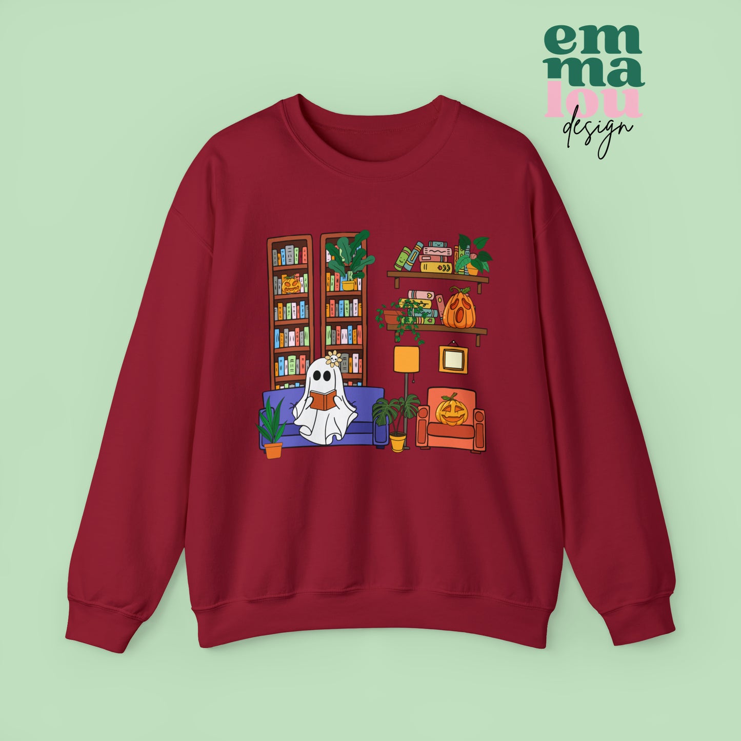 Red Gildan Crewneck Sweatshirt Featuring a Graphic design featuring a cute ghost with a floral bow reading on a purple couch surrounded by cute house plants and 2 bookcases and shelves with books