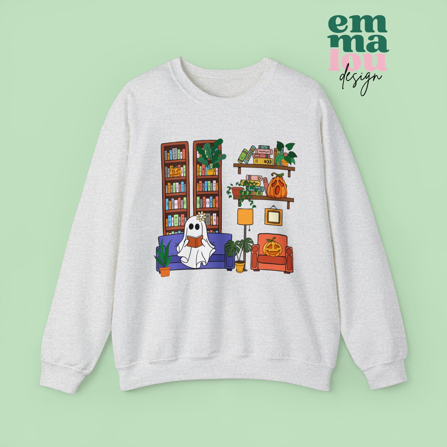 White Gildan Crewneck Sweatshirt Featuring a Graphic design featuring a cute ghost with a floral bow reading on a purple couch surrounded by cute house plants and 2 bookcases and shelves with books