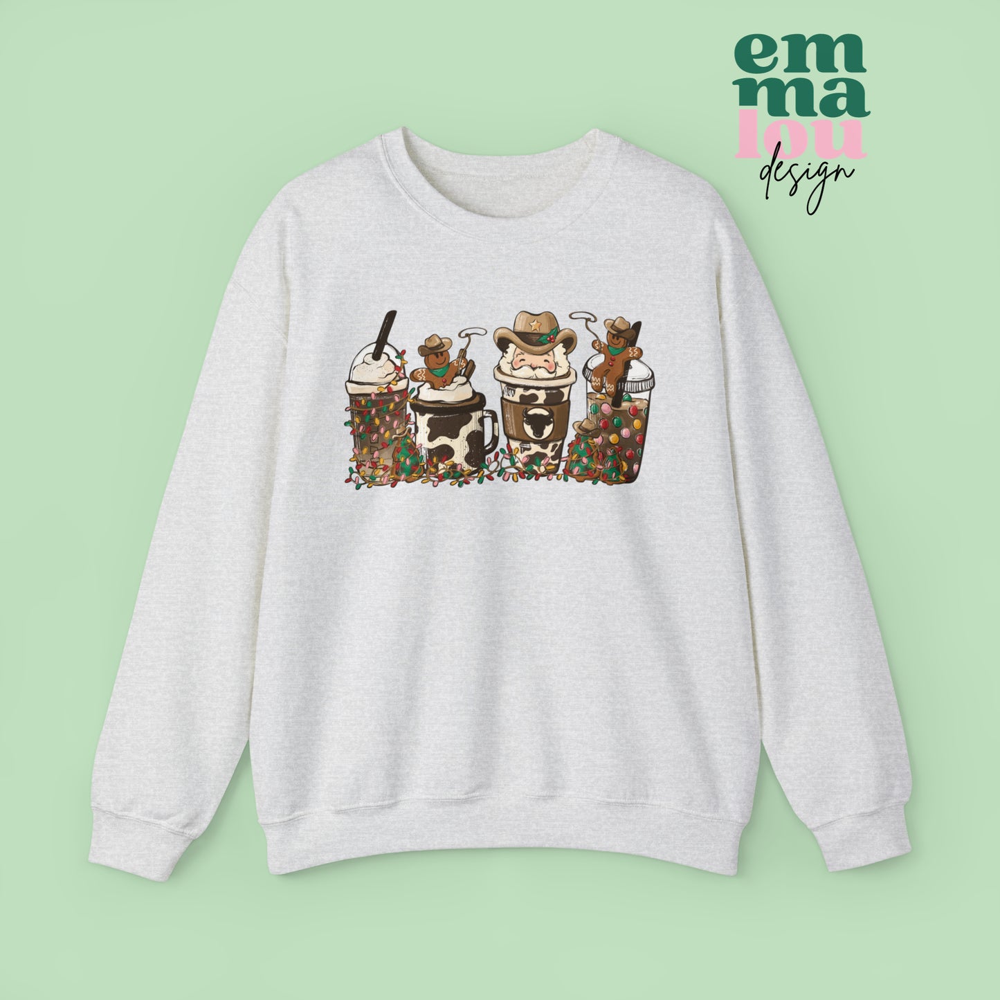 Ash Grey  Sweatshirt featuring four western christmas coffee lattes. The graphic includes two cowboy gingerbread men and a westner Santa Claus with cow print coffee drins and christmas lights.