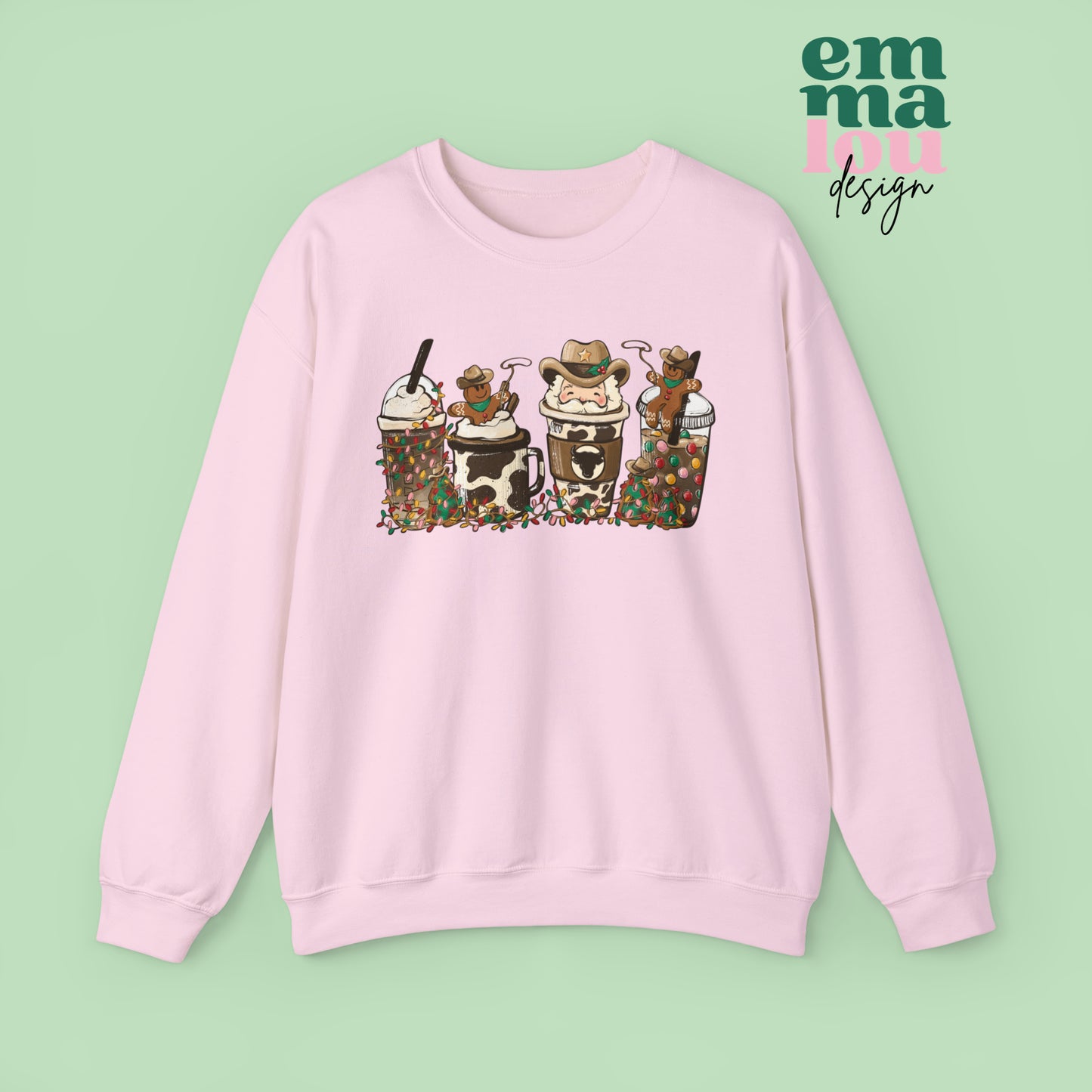 Light Pink  Sweatshirt featuring four western christmas coffee lattes. The graphic includes two cowboy gingerbread men and a westner Santa Claus with cow print coffee drins and christmas lights.