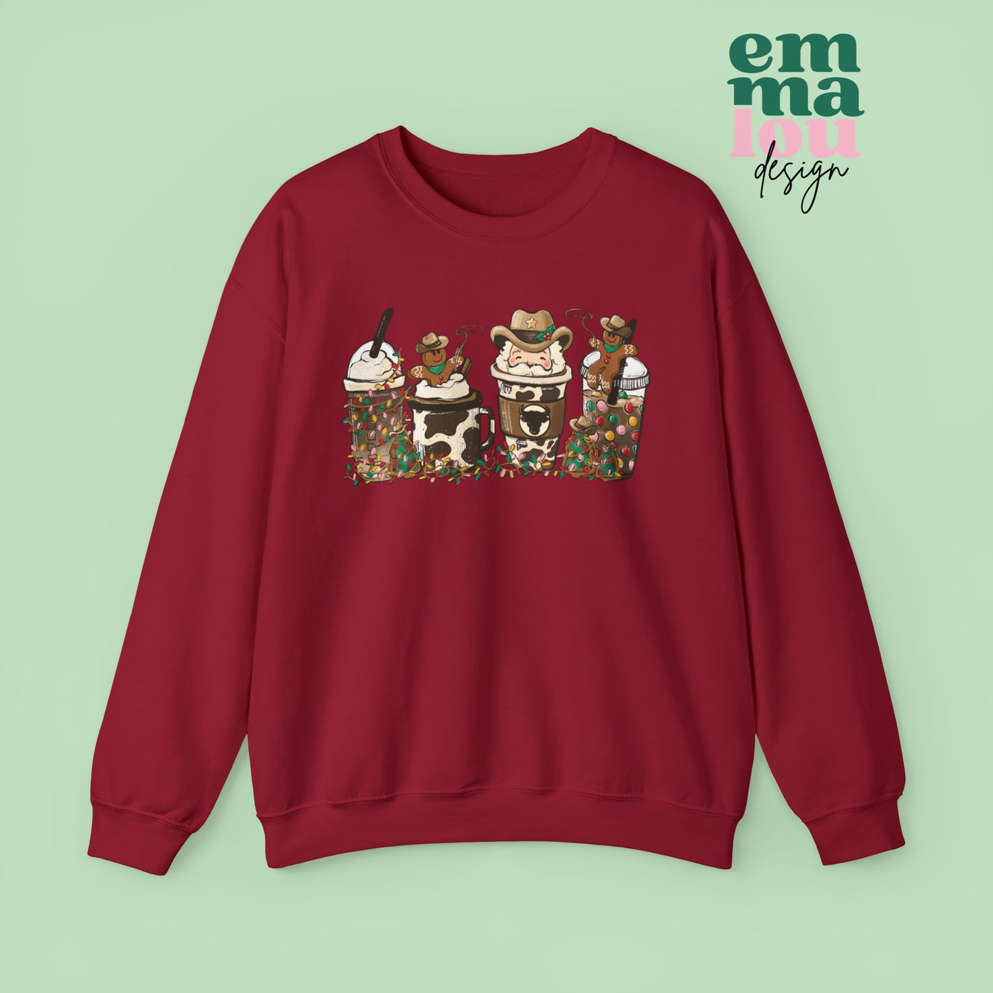 Red  Sweatshirt featuring four western christmas coffee lattes. The graphic includes two cowboy gingerbread men and a westner Santa Claus with cow print coffee drins and christmas lights.