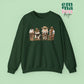 Forest Green  Sweatshirt featuring four western christmas coffee lattes. The graphic includes two cowboy gingerbread men and a westner Santa Claus with cow print coffee drins and christmas lights.